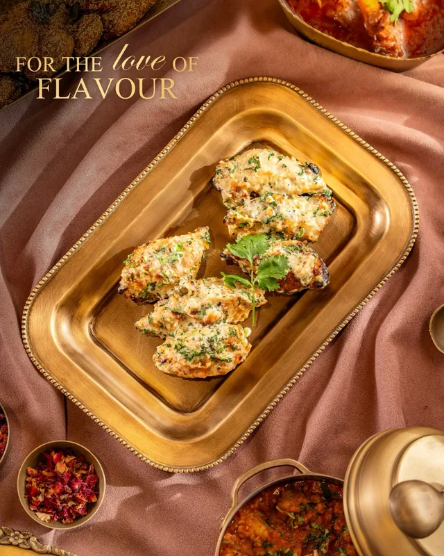 Stuffed kebabs on a brass platter with rose petals.